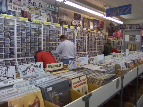 The long aisle of LPs and the wall of cassettes on the back wall